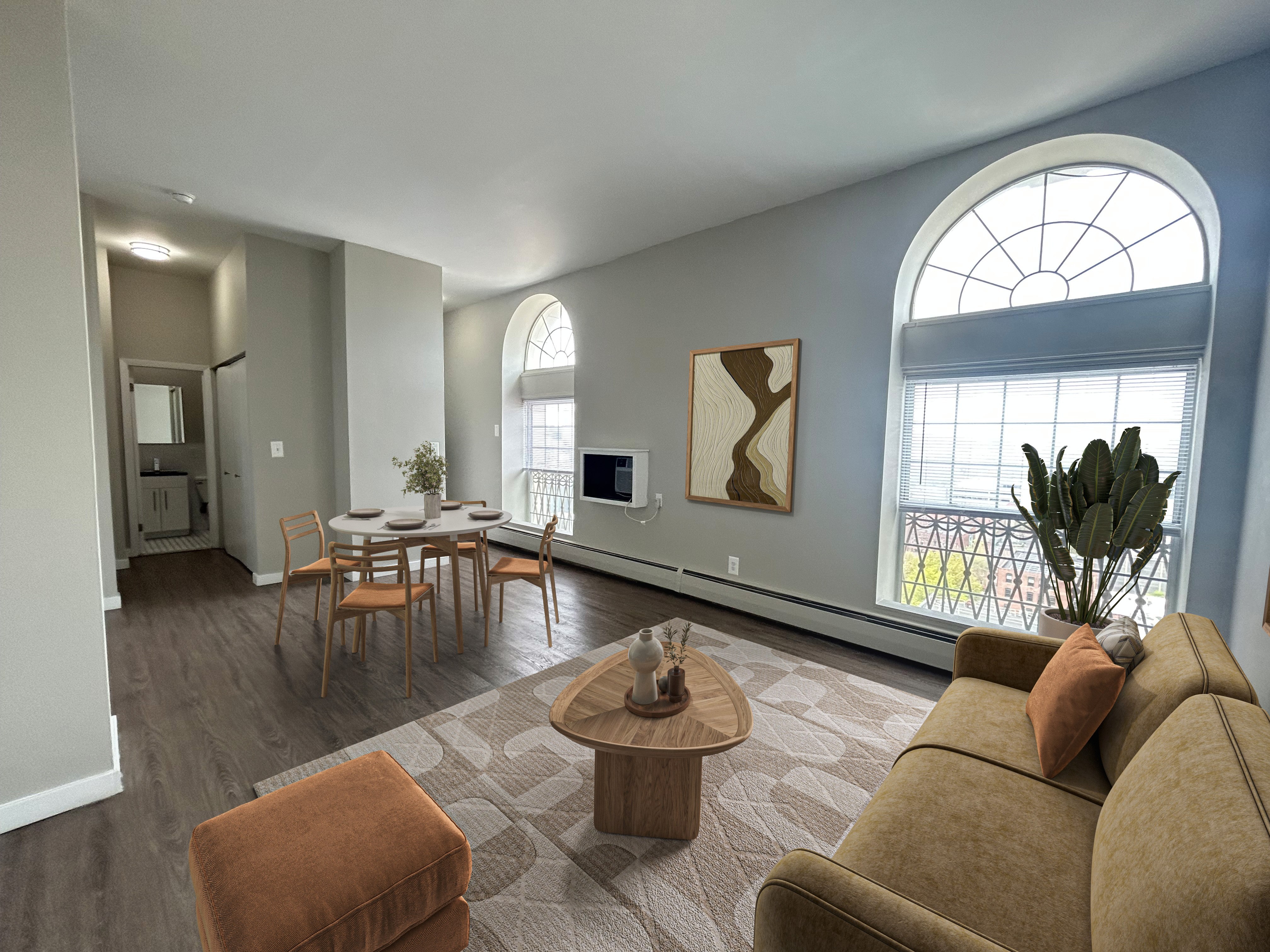 A living room with a brown couch, a coffee table, and a dining table with chairs.